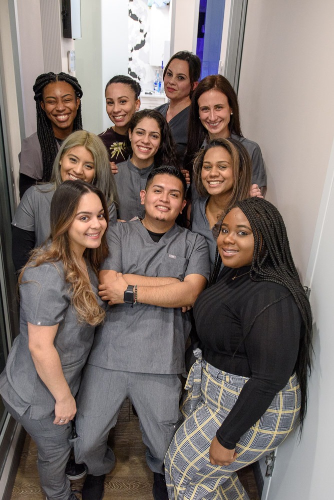 The Soul Dental team of hygienists, assistants, and front desk staff pose close together. They appear to be a fun work family.